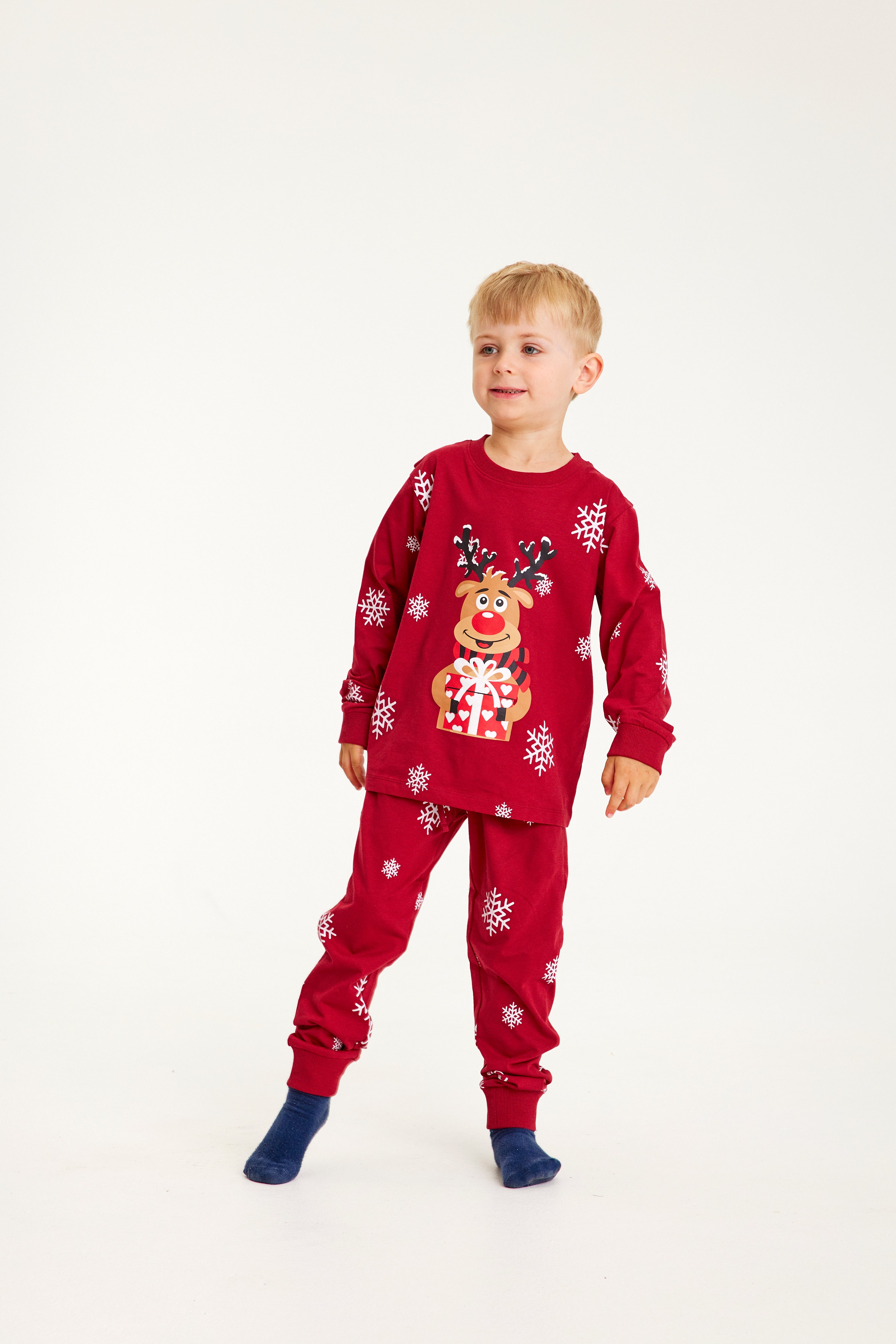 Et barn iført røde julepyjamas.